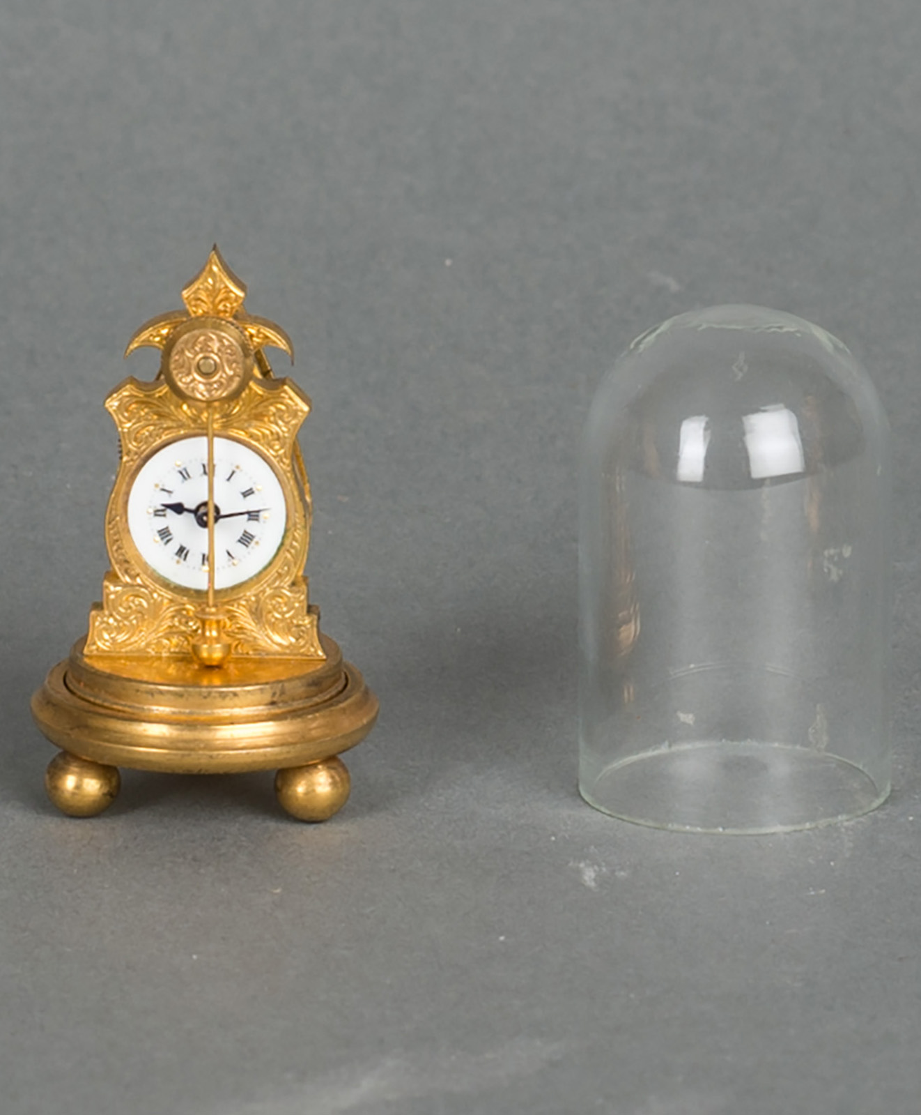 A very small and unusual Austrian ormolu zappler miniature clock with matching dome and enamel dial, circa 1860