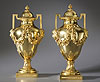 A fine pair of Louis XVI gilt bronze covered urns, each of ovoid form with a domed-shaped cover 