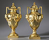 A fine pair of Louis XVI gilt bronze covered urns, each of ovoid form with a domed-shaped cover