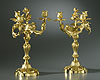 A superb pair of Louis XV gilt bronze three-light candelabra, each of asymmetrical scrolling form, with a central surmounting removable spiralling foliate and floral finial above intertwining sinuous scrolling branches