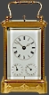 AN ENGRAVED CORNICHE CASED QUARTER STRIKING CARRIAGE CLOCK WITH ALARM AND DATE.